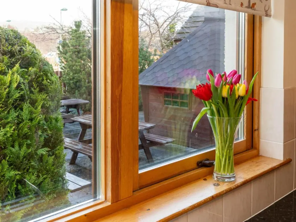 a vase of flowers sitting on a window sill at Villa Craigmore Lodge by Interhome in Aviemore
