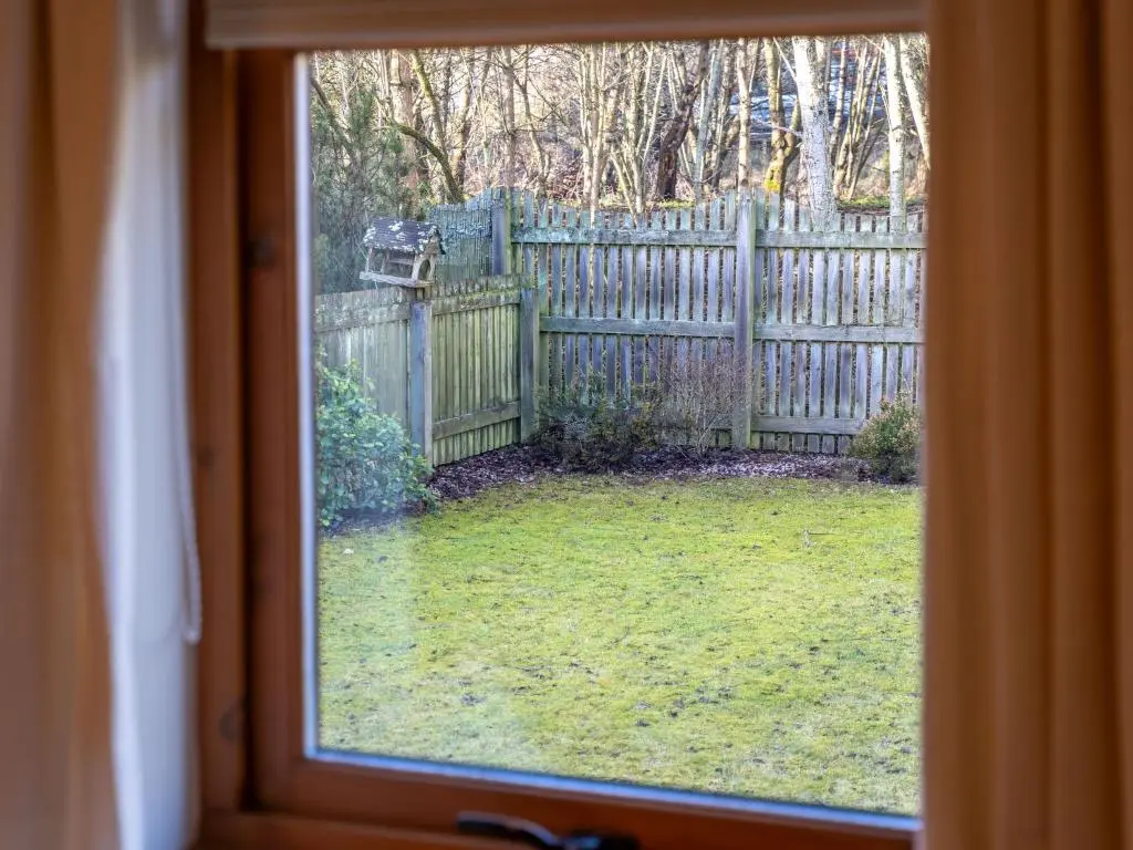 a window view of a yard with a fence at Holiday Home Culduthel by Interhome in Aviemore