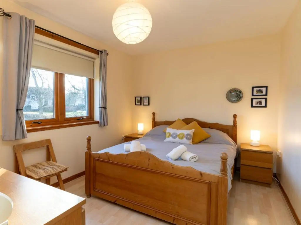 a bedroom with a bed with towels on it at Holiday Home Culduthel by Interhome in Aviemore