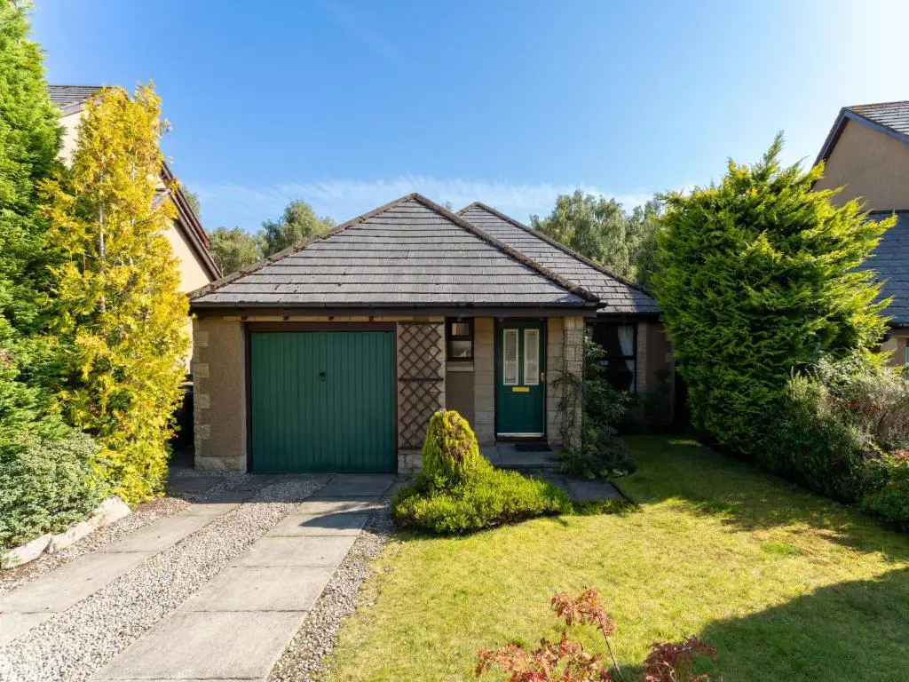 a small house with a green garage at Holiday Home Glenpark by Interhome in Aviemore