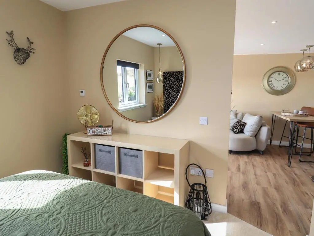 a bedroom with a bed and a mirror at Core-na-bye in Inverness