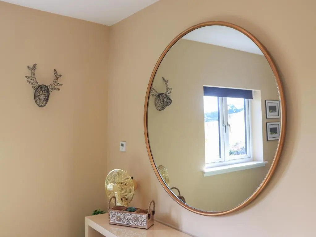 a bathroom with a large mirror on the wall at Core-na-bye in Inverness