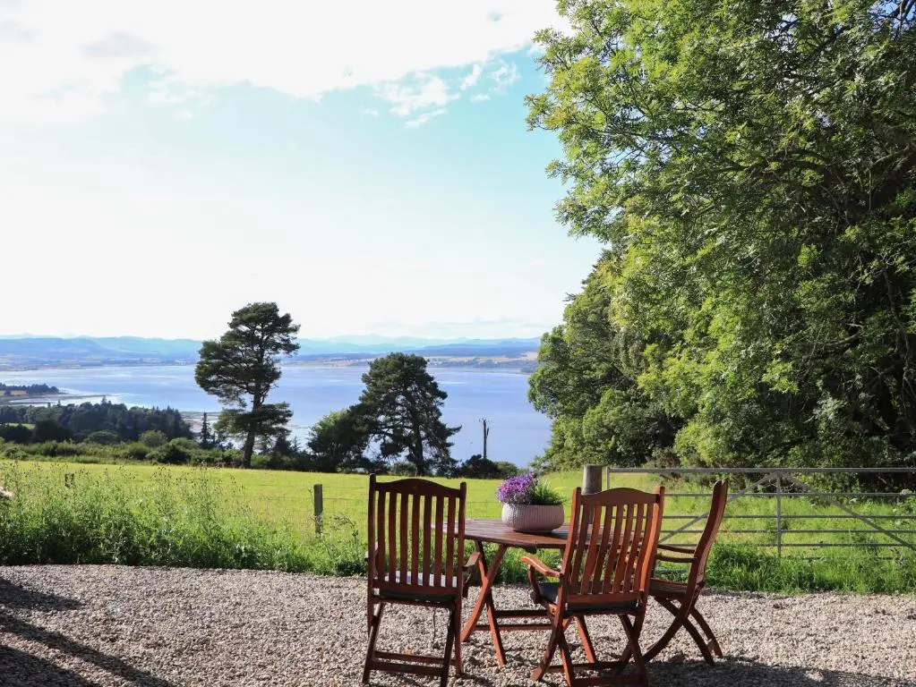 a table and chairs with a view of the water at Core-na-bye in Inverness