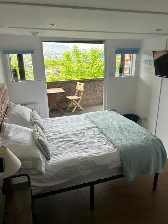 a bedroom with a large bed and a balcony at Floras View in Inverness