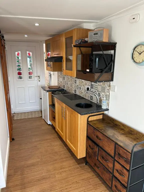 a kitchen with wooden cabinets and a microwave at Floras View in Inverness