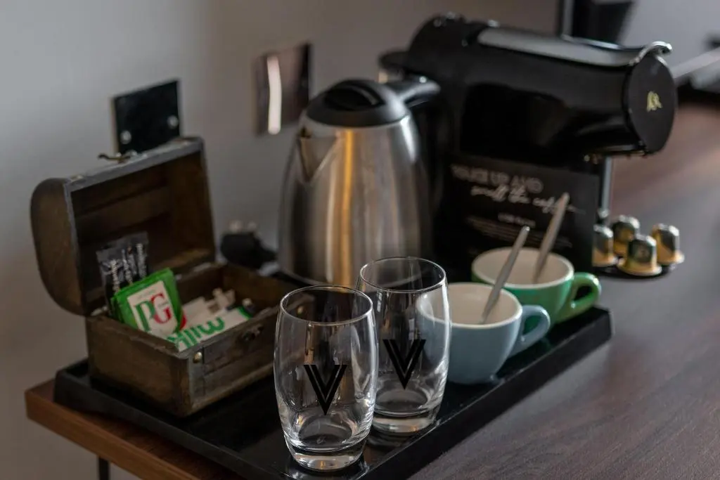 two glasses on a counter next to a coffee maker at Village Hotel Aberdeen in Aberdeen