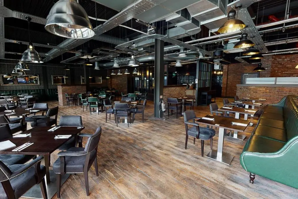 a dining room with wooden tables and chairs at Village Hotel Aberdeen in Aberdeen