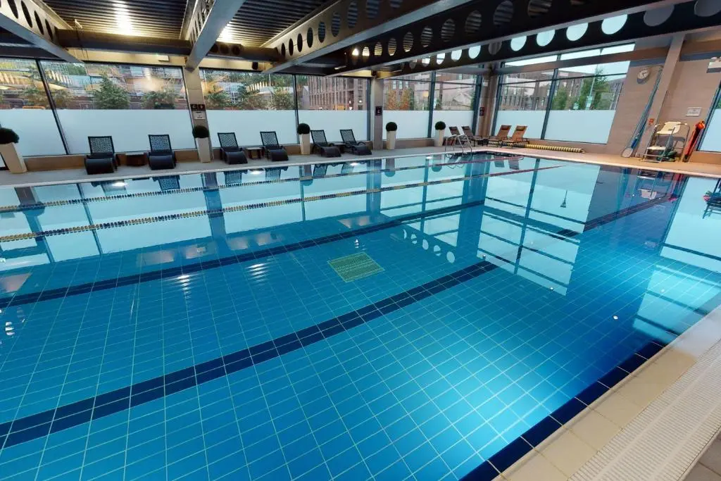 a large swimming pool with blue tiles in a building at Village Hotel Aberdeen in Aberdeen