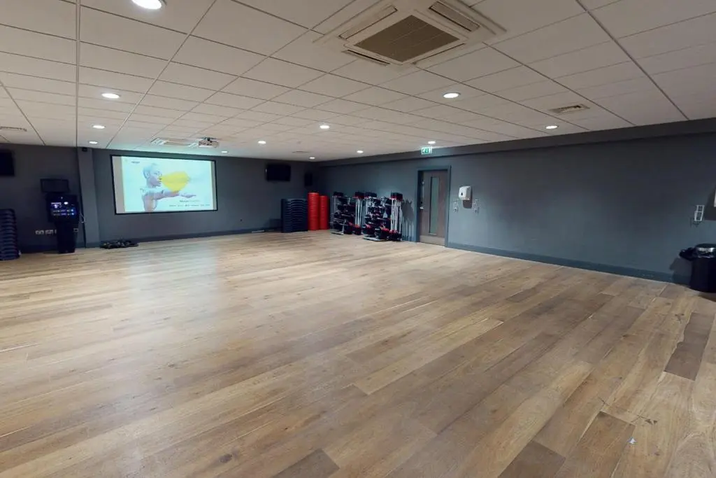 a large room with a wooden floor and a projection screen at Village Hotel Aberdeen in Aberdeen