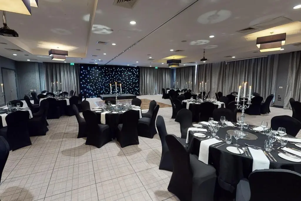 a banquet hall with tables and chairs in a room at Village Hotel Aberdeen in Aberdeen