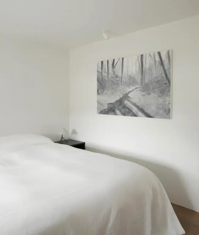 a bedroom with a white bed with a picture on the wall at Laggan Cottage - Charming home along River Gairn with unique panoramic room in Ballater