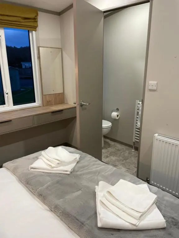 a bedroom with a bed with white towels on it at The Drey in Grantown on Spey