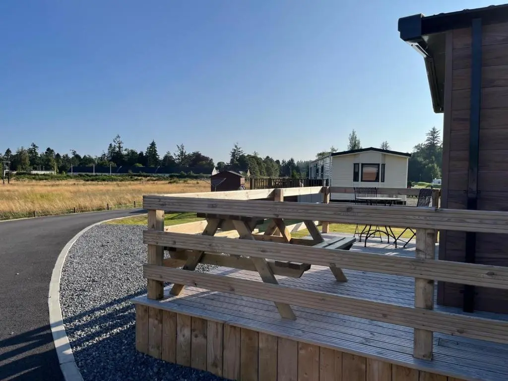 a wooden picnic table on the side of a road at The Drey in Grantown on Spey
