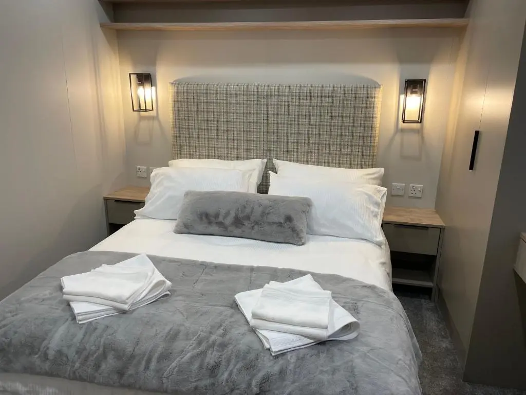 a bed with two towels on top of it at The Drey in Grantown on Spey