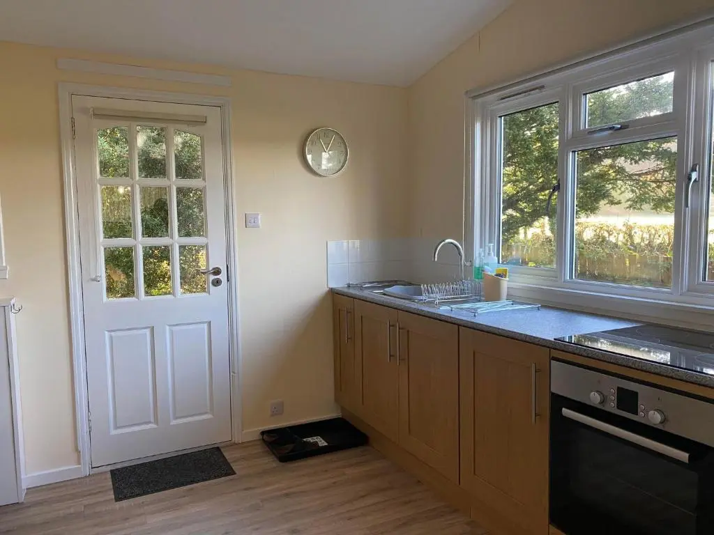 a kitchen with a sink and a counter with a window at Burnside Chalet on Reelig Estate in Kirkhill