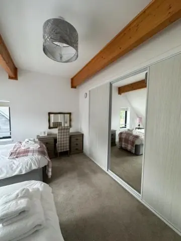 a bedroom with a mirror and a bed and a desk at Highland Holiday Home in Contin