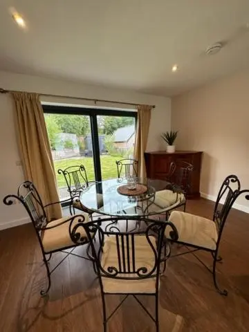 a dining room with a glass table and chairs at Highland Holiday Home in Contin