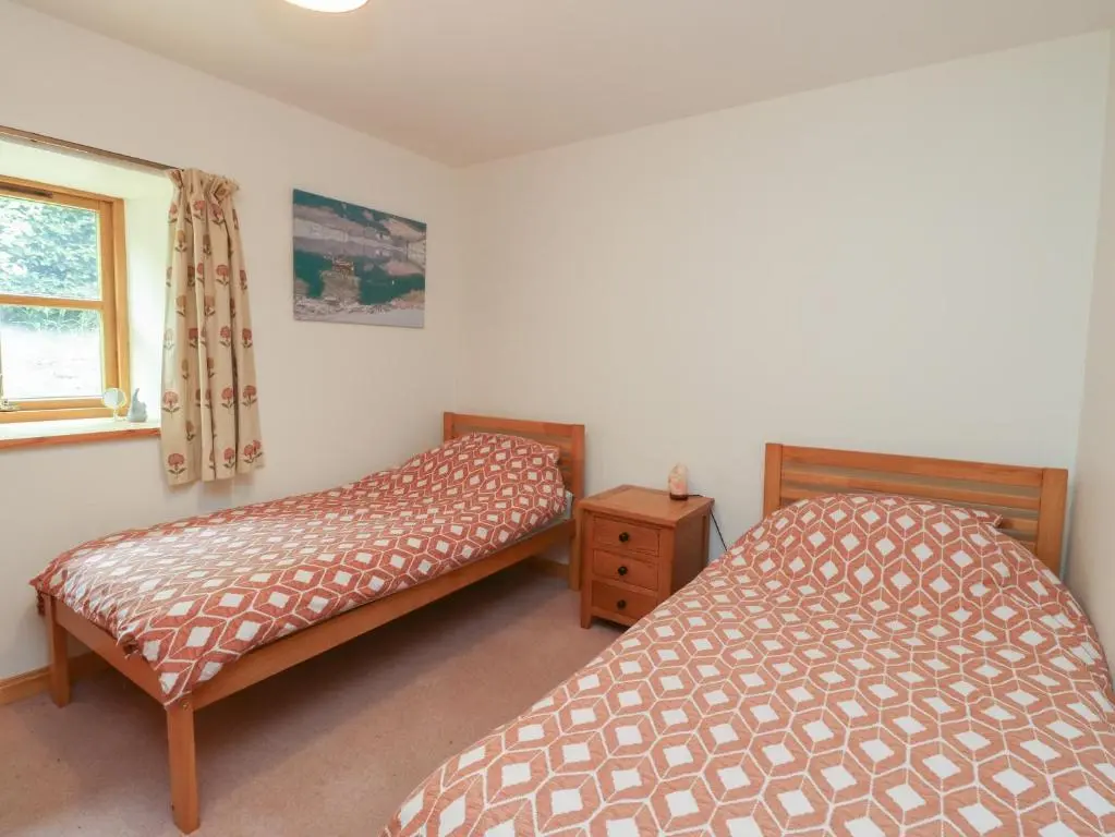 a bedroom with two beds and a window at The Milk House in Fortrose