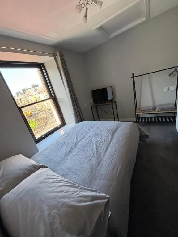 a bedroom with a white bed and a window at Argyle House Wick in Wick