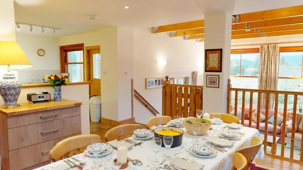 a kitchen and dining room with a table and chairs at Carriden in Insh