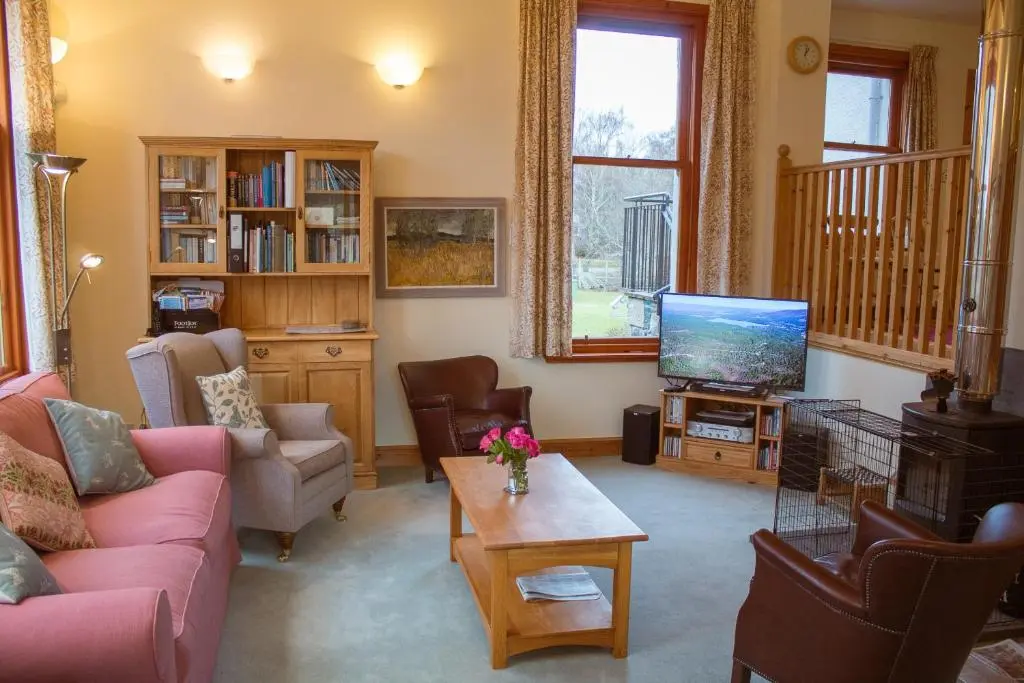 a living room with a couch and a tv at Carriden in Insh