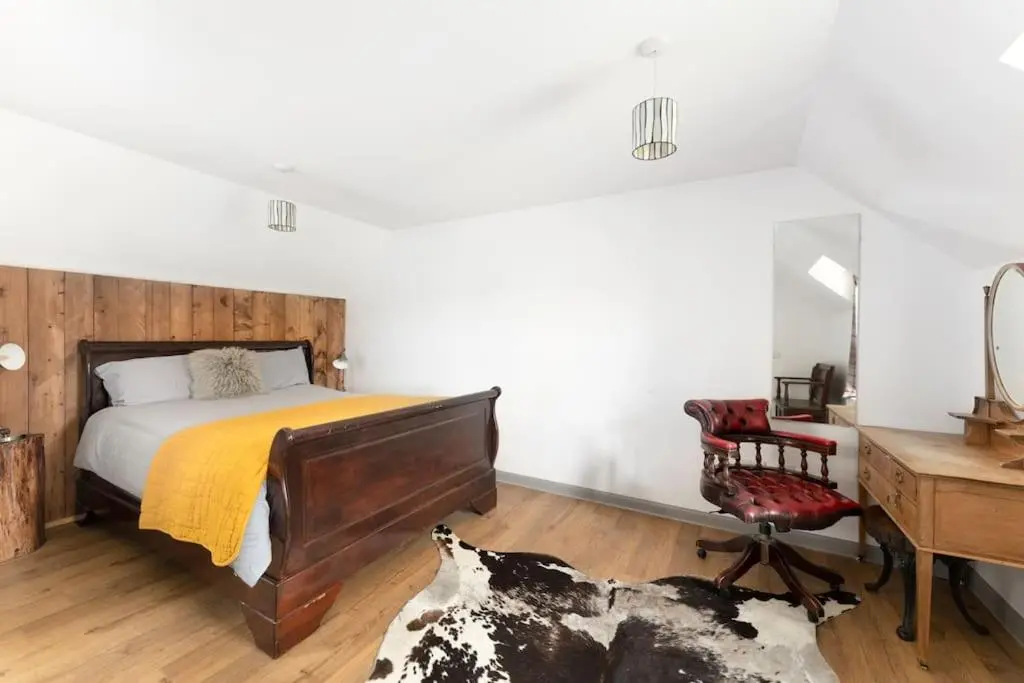 a bedroom with a bed and a desk and a chair at Jacobite Lodge by The House of Danu in Kingussie
