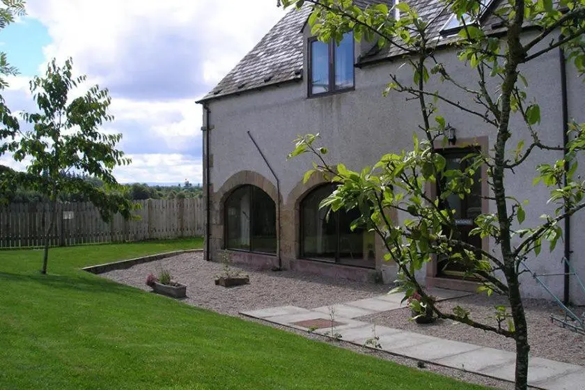a house with a garden and a yard with a tree at Red Kite in Belmaduthy