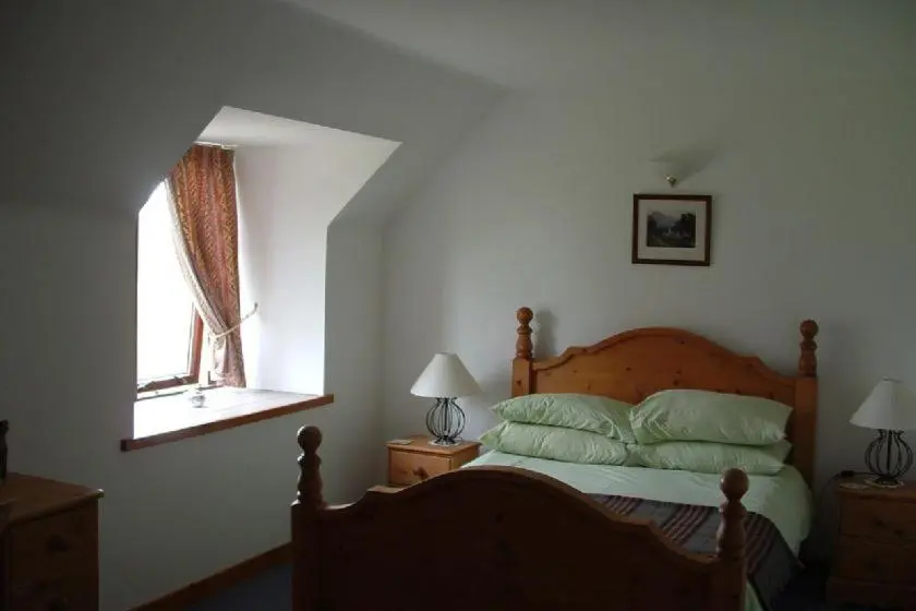a bedroom with a bed and a window at Red Kite in Belmaduthy