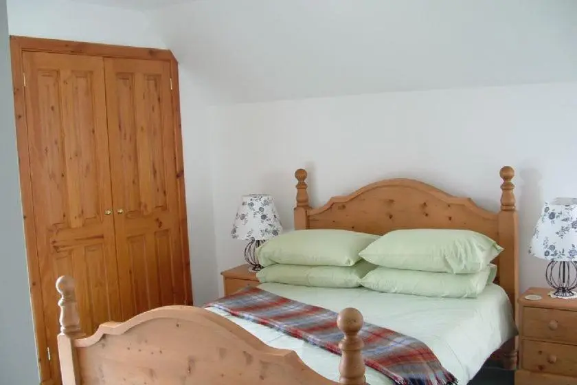 a bedroom with a bed with two pillows on it at Mackenzie in Belmaduthy