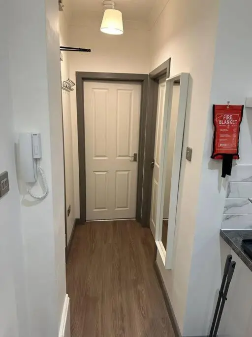 a hallway with a white door and a phone at Riverview Apartment, Inverness in Inverness