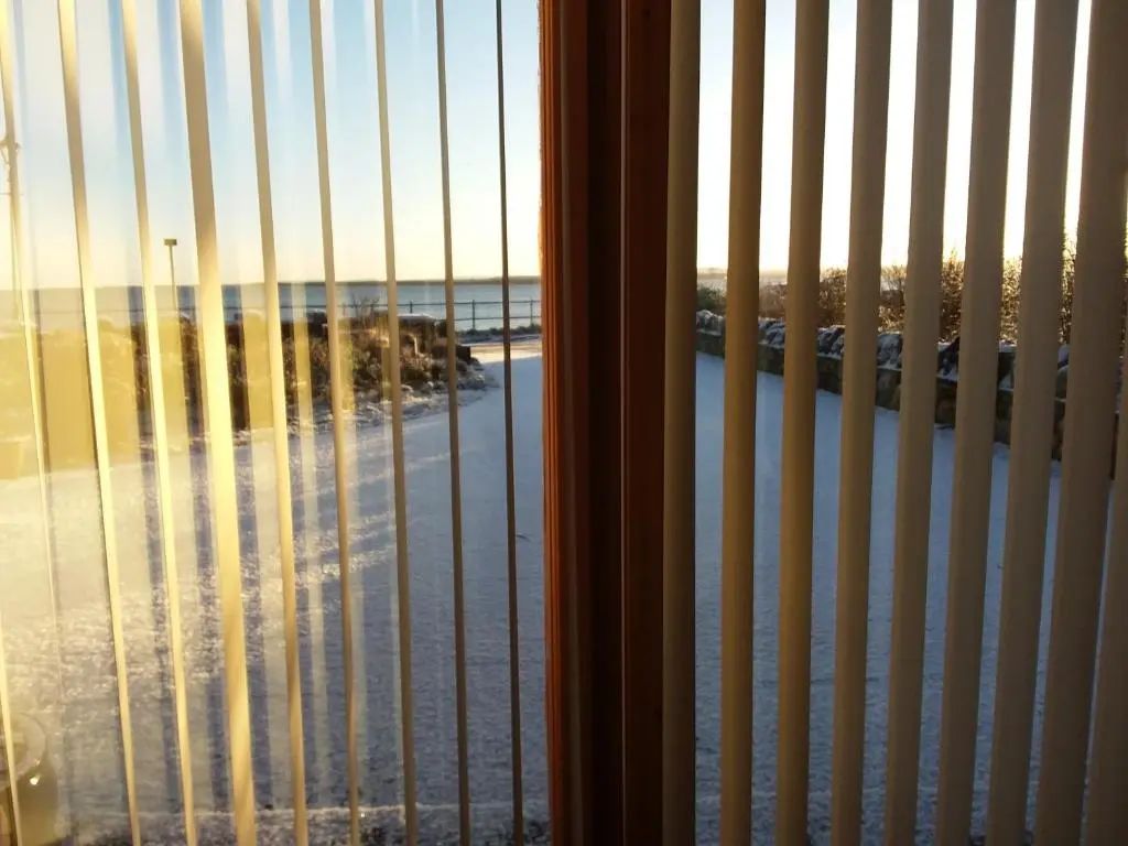 a view of the beach from a window with bars at Ceol Na Mara (Music of the Sea) in Rosemarkie
