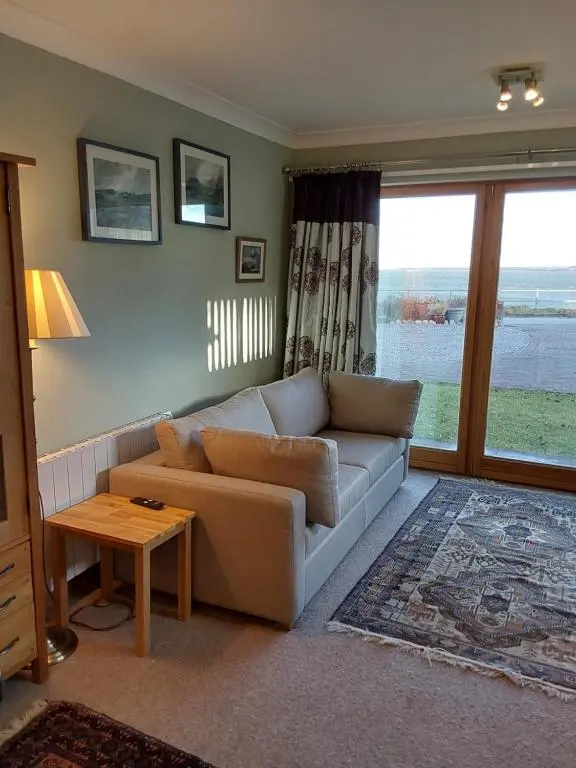 a living room with a couch and a table at Ceol Na Mara (Music of the Sea) in Rosemarkie