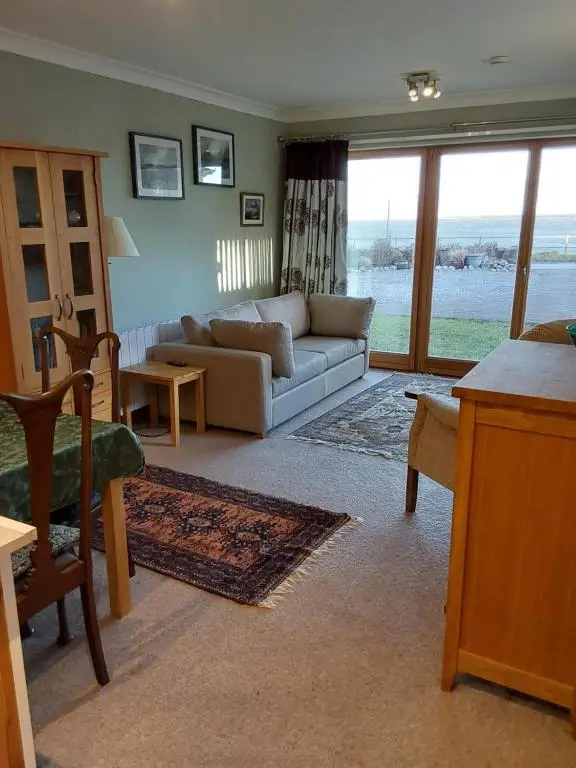 a living room with a couch and a table at Ceol Na Mara (Music of the Sea) in Rosemarkie