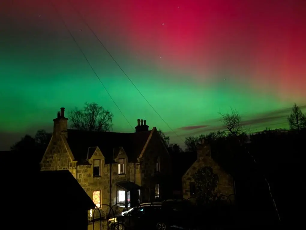 an aurora in the sky above a house at Old School in Kingussie