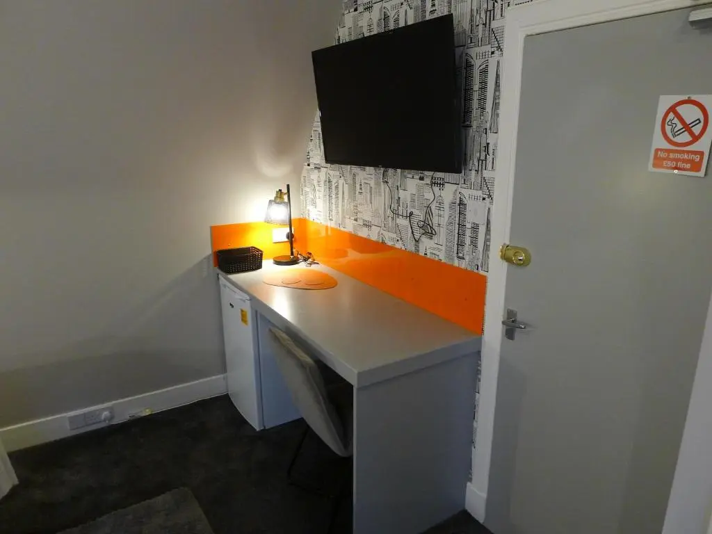 a room with a desk with a television on it at Saltoun House in Fraserburgh