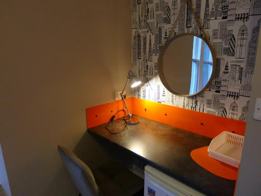 a desk with a mirror and a lamp on it at Saltoun House in Fraserburgh