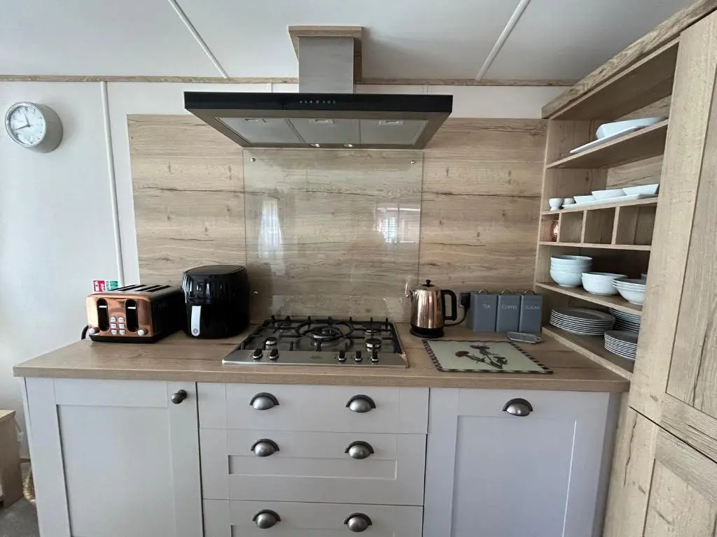 a kitchen with a stove top oven in a kitchen at Lodge 2 The Wee Hut Aviemore in Aviemore