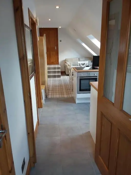 a hallway leading to a kitchen with an open door at Top Floor Flat Ceol Na Mara (Music of the Sea) in Rosemarkie