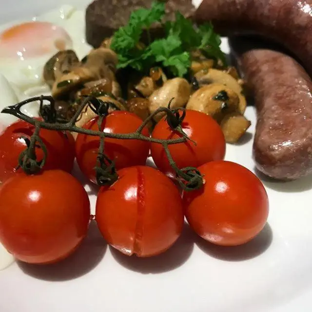 a plate of tomatoes and other foods on a plate at Ardlogie Guest House in Aviemore