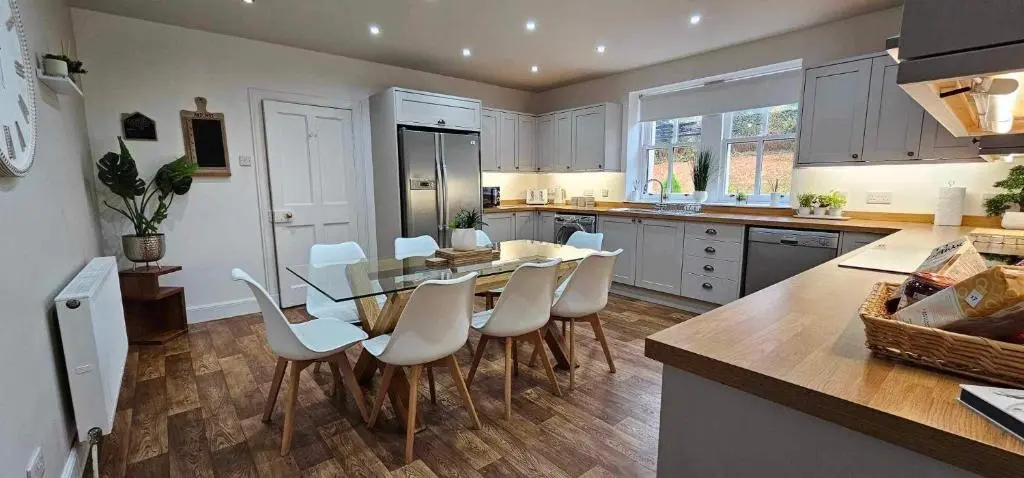 a kitchen with a table and chairs in a kitchen at Antfield House in Inverness