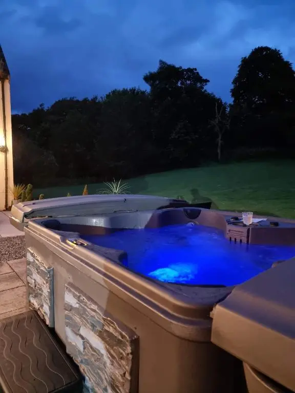 a blue hot tub in a backyard at night at Antfield House in Inverness