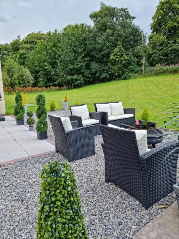 a patio with wicker chairs and a grill at Antfield House in Inverness