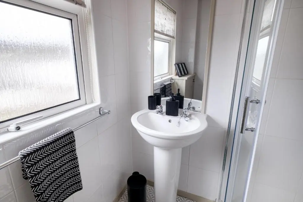 a white bathroom with a sink and a window at Banchory House - SJA Stays - 2 Bed House in Banchory
