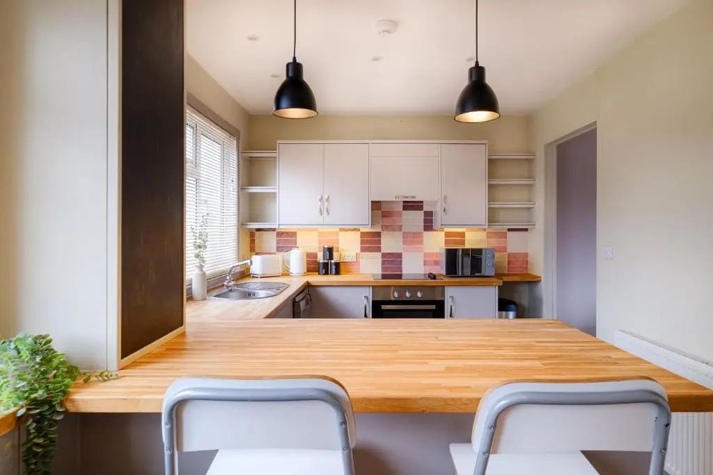 a kitchen with a wooden table and two chairs at Banchory House - SJA Stays - 2 Bed House in Banchory