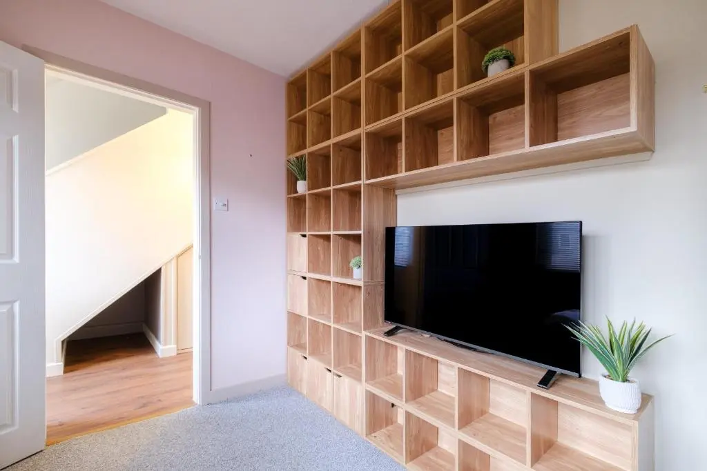 a living room with a tv and a wall of shelves at Banchory House - SJA Stays - 2 Bed House in Banchory