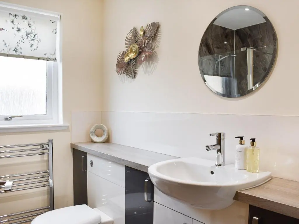 a bathroom with a sink and a mirror at Rycon in Turriff