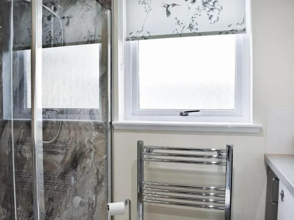 a bathroom with a shower and a window at Rycon in Turriff