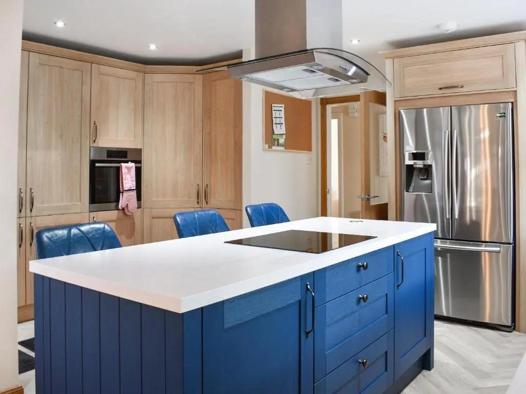 a kitchen with blue cabinets and a blue island at Rycon in Turriff