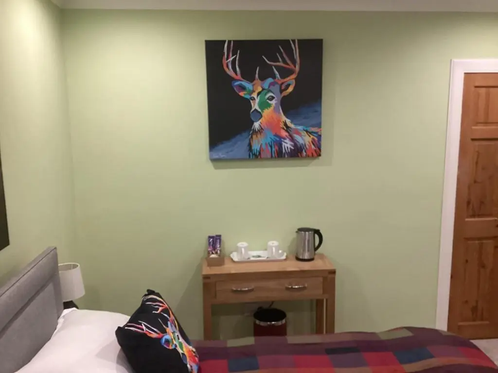 a bedroom with a painting of a deer on the wall at Taigh Sealladh F\u00e8idh B&B in Fort Augustus