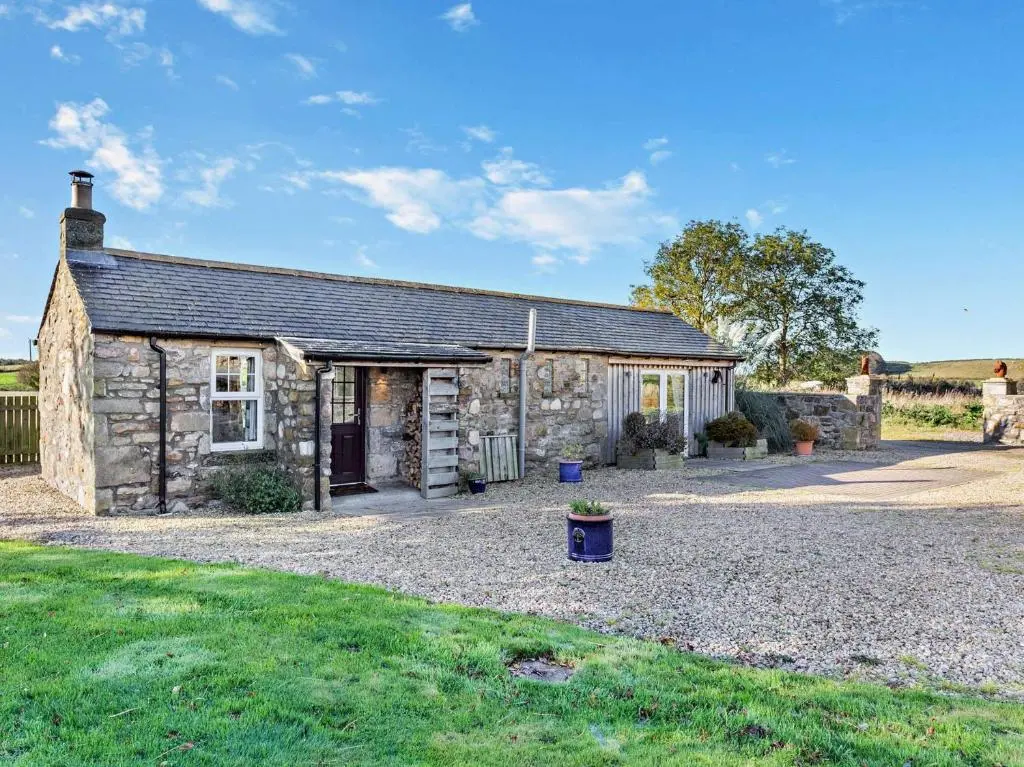 an old stone cottage with a gravel driveway at 1 Bed in Elgin 32129 in Burghead
